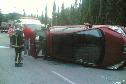 Bomberos y sanitarios del 112 intervienen tras un accidente en el que volcó un coche en Hoyo de Manzanares (Madrid).