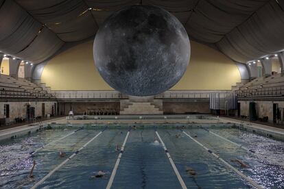 La obra 'Museo de la Luna' del artista británico Luke Jerram, suspendido sobre nadadores en la piscina Cozzi de Milán, Italia. El 'Museo de la Luna' es una réplica esférica de la luna, con un diámetro de 7 metros, en una escala de 1: 500,000, o de 1 centímetro a 5 kilómetros.