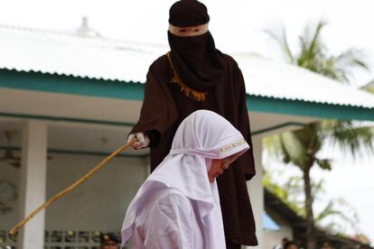 Una mujer es azotada en público por violar la 'sharía' o ley islámica, en Banda Aceh, Indonesia.