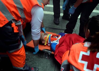 Un herido es atendido por los servicios de emergencia durante el cuarto encierro.