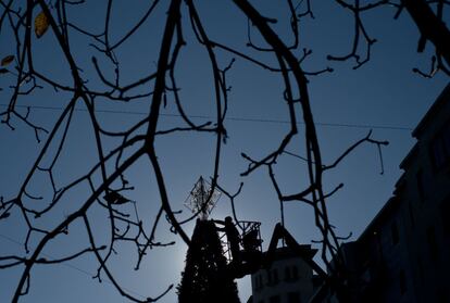 Un trabajador pone una estrella a un árbol de Navidad que adorna la ciudad durante las fiestas navideñas en Pamplona (España), 28 de noviembre 2013.