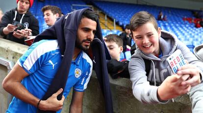 Riyad Mahrez se hace una foto con un aficionado.