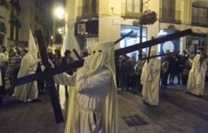 Un miembro de la Cofradía de la Institución de la Sagrada Eucaristía durante su procesión de esta noche de Jueves Santo por las calles del casco histórico de Zaragoza. EFE/Archivo