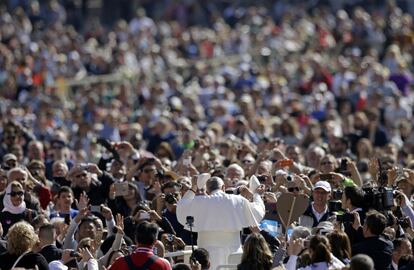 El papa Francisco cambia su solideo (casquete blanco) con un peregrino que le ha ofrecido su gorro en la Plaza de San Pedro en el Vaticano.