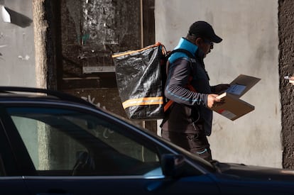 Un hombre reparte paquetes en una calle de Santander.