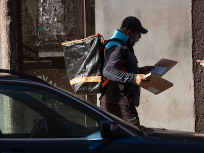 Un hombre reparte paquetes en una calle de Santander.