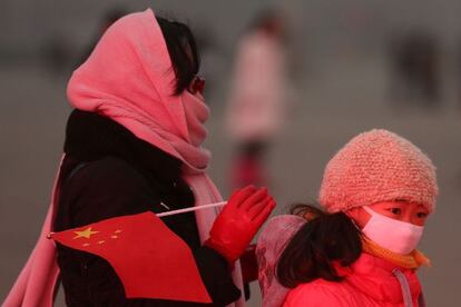 Una mujer y su hija se protegen de la contaminación de Pekín.