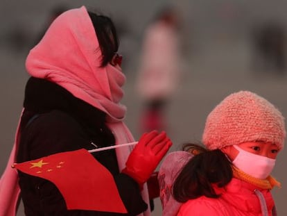 Una mujer y su hija se protegen de la contaminación de Pekín.