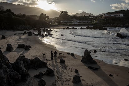 Dos mujeres con sus perros en la playa de Toró, Llanes, el 21 de enero.