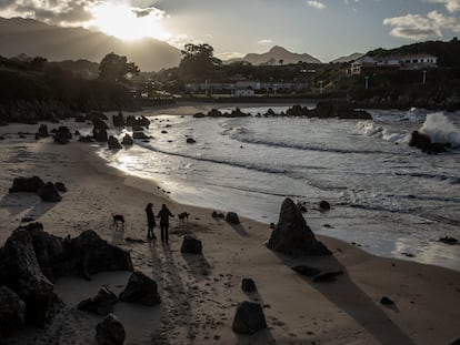 Dos mujeres con sus perros en la playa de Toró, Llanes, el 21 de enero.