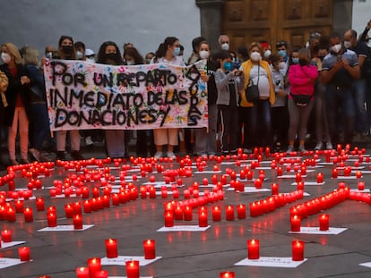 Un grupo de personas sostiene una pancarta durante una concentración en la Plaza de España de Los Llanos de Aridane, a 27 de diciembre de 2021, en La Palma.