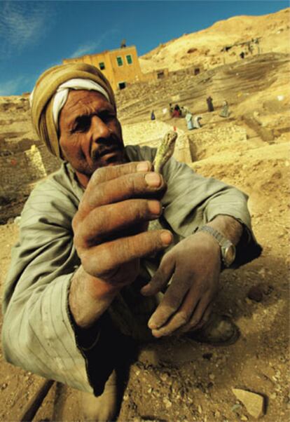 Para la labor en las tumbas de Dra Abu el Naga, que se realiza entre las siete de la mañana y la una de la tarde, se cuenta con 70 trabajadores egipcios. Uno de ellos muestra una pieza encontrada.