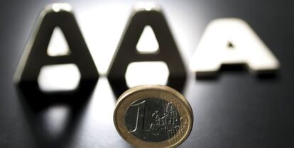 En la imagen, una moneda de euro junto a tres letras &quot;A&quot;, una de las cuales aparece tumbada. 