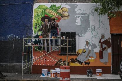Un hombre pinta un mural en la Casa de la Cultura de San Pablo Oztotepec en Milpa Alta.