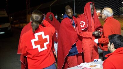 Personal de Cruz Roja atiende a inmigrantes rescatados de una patera en Motril.