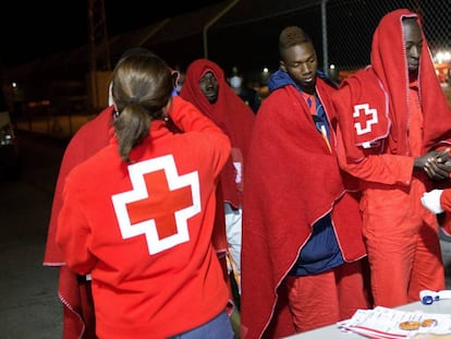 Personal de Cruz Roja atiende a inmigrantes rescatados de una patera en Motril.