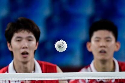 La pareja china Li Junhui y Liu Yuchen de China miran la pluma durante el partido de semifinales de bádminton de dobles masculinos contra Soh Wooi Yik y Aaron Chia, de Malasia.