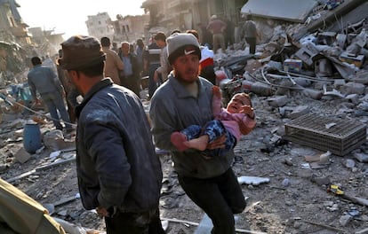 Un hombre sostiene en sus brazos a un niño tras los bombardeos aéreos en un mercado en Atareb, en el norte de Siria, este lunes.