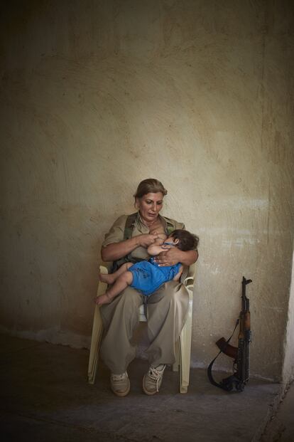 Sulaymaniyah, Irak, septiembre de 2014. Shaista la 'peshmerga' amamanta a su hijo de 10 meses.