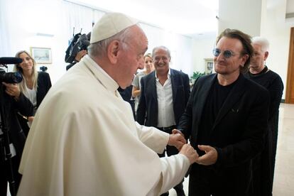 El cantante de U2 Bono saluda al papa Francisco durante un encuentro en el Vaticano.