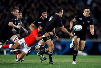 Kahui de los 'All Blacks' pasa el balón a Sony Bill Williams durante el partido inaugural del Mundial de Nueva Zelanda contra mientras un tongano intenta placarle.