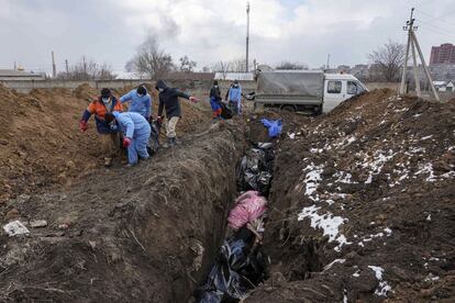 Entierro de cadáveres en una fosa común a las afueras de Mariupol, el 9 de marzo.