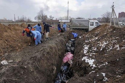 Entierro de cadáveres en una fosa común a las afueras de Mariupol, el 9 de marzo.