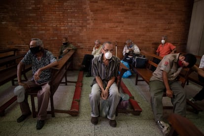 Un grupo de personas espera para recibir alimentos gratuitos en una iglesia de Caracas, Venezuela