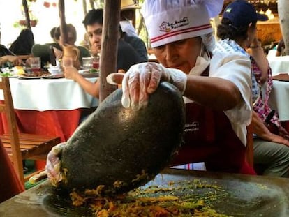 Cozinheira esmaga alimentos num ‘batán’ no restaurante La Nueva Palomino, em Arequipa.