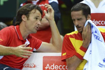 Spain captain Carlos Moy&aacute; speaks to Feliciano L&oacute;pez during the latter&#039;s match against Florian Mayer.  