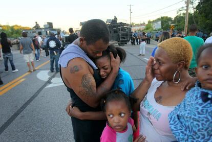 La familia Williams se abrazan después de los enfrentamientos. La policía asegura que el joven, que iba desarmado y recibió varios disparos, atacó al agente en el interior de su vehículo.