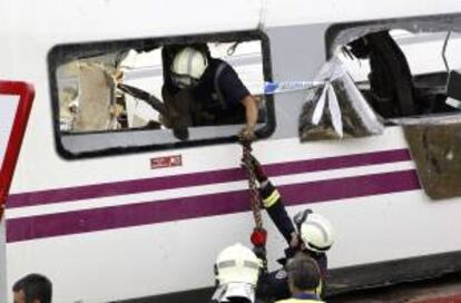 Los bomberos trabajan en uno de los vagones del convoy siniestrado el pasado 25 de julio en Santiago de Compostela. EFE/Archivo