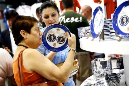 Una mujer sujeta un plato, con la imagen de los futuros Reyes de España, en una tienda en Madrid.