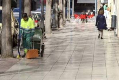 Un empleado de la empresa UTE realiza su trabajo en una céntrica calle de la ciudad de Alicante tras el acuerdo entre trabajadores y empresa y haber desconvocado la huelga.