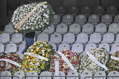 Un hombre lleva un ramo de flores en las gradas del estadio Vila Belmiro, en Santos (Brasil).  