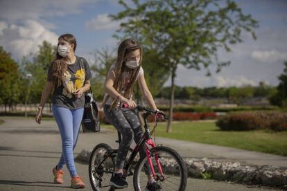 Una mujer pasea por el parque con su hija.