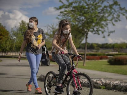 Una mujer pasea por el parque con su hija.