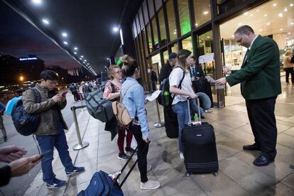 Un trabajador de Renfe comprueba los billetes de los viajeros que entran en la estación de Sants.