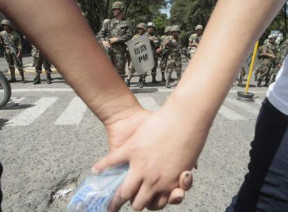 Seguidores del presidente depuesto Manuel Zelaya, protestan hoy frente a un contingente de militares en la capital hondureña