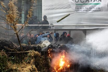 Un grupo de agricultores tiran objetos a la policía este lunes en el centro de Bruselas.