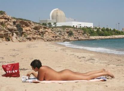 Una joven practica el nudismo junto a la nuclear en la playa de l'Almadrava.
