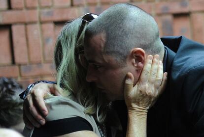 Han hecho falta cuatro días de sesiones para que el juez sudafricano Desmond Nair decidiera la libertad bajo fianza para Pistorius. En la imagen, varios familiares del atleta se abrazan durante la audiencia de hoy viernes.