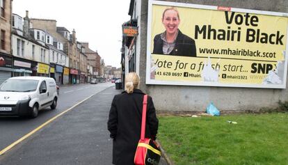 Mhairi Black, candidata del Partidt Nacionalista Escocès (SNP), mira un cartell electoral amb la seva imatge a Paisley.