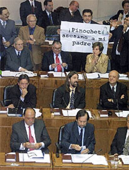El diputado Fidel Espinoza muestra una pancarta contra Pinochet.