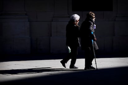 Dos mujeres mayores caminan cogidas del brazo este viernes en Sevilla. PACO PUENTES (EL PAÍS).