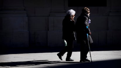 Dos mujeres mayores caminan cogidas del brazo este viernes en Sevilla. PACO PUENTES (EL PAÍS).