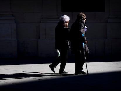 Dos mujeres mayores caminan cogidas del brazo este viernes en Sevilla. PACO PUENTES (EL PAÍS).