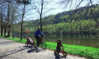 Una familia pasea en bicicleta por la orilla del Elba, en Sajonia.