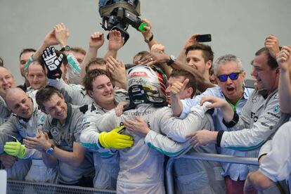 Mercedes driver Lewis Hamilton (C) of Britain celebrates with his teammates after winning the Formula One Malaysian Grand Prix at the Sepang circuit near Kuala Lumpur on March 30, 2014.    AFP PHOTO / Ed Jones