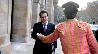 Artur Mas recibe una octavilla de un partidario protaurino disfrazado de torero a la salida, ayer, del Parlamento de Cataluña.